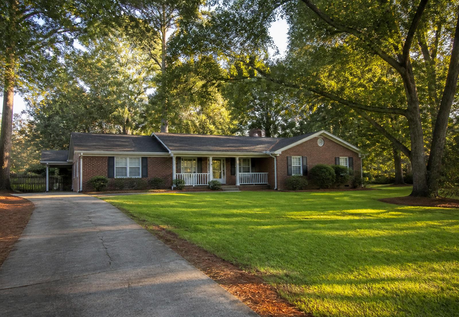 Brick Georgia home with a wide front porch at golden hour